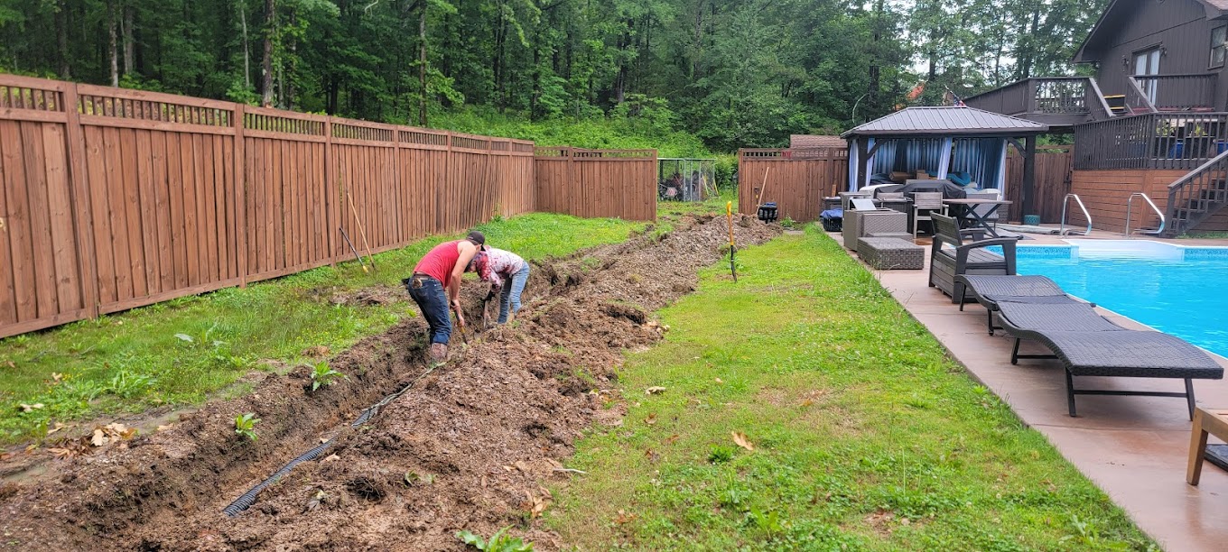 Drain line trenching through a backyard near a pool