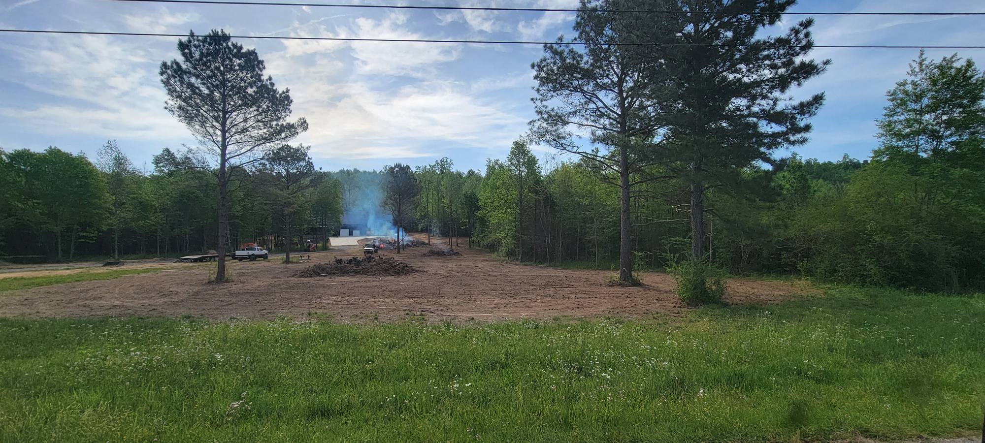 Cleared lot with burn pile ready for construction